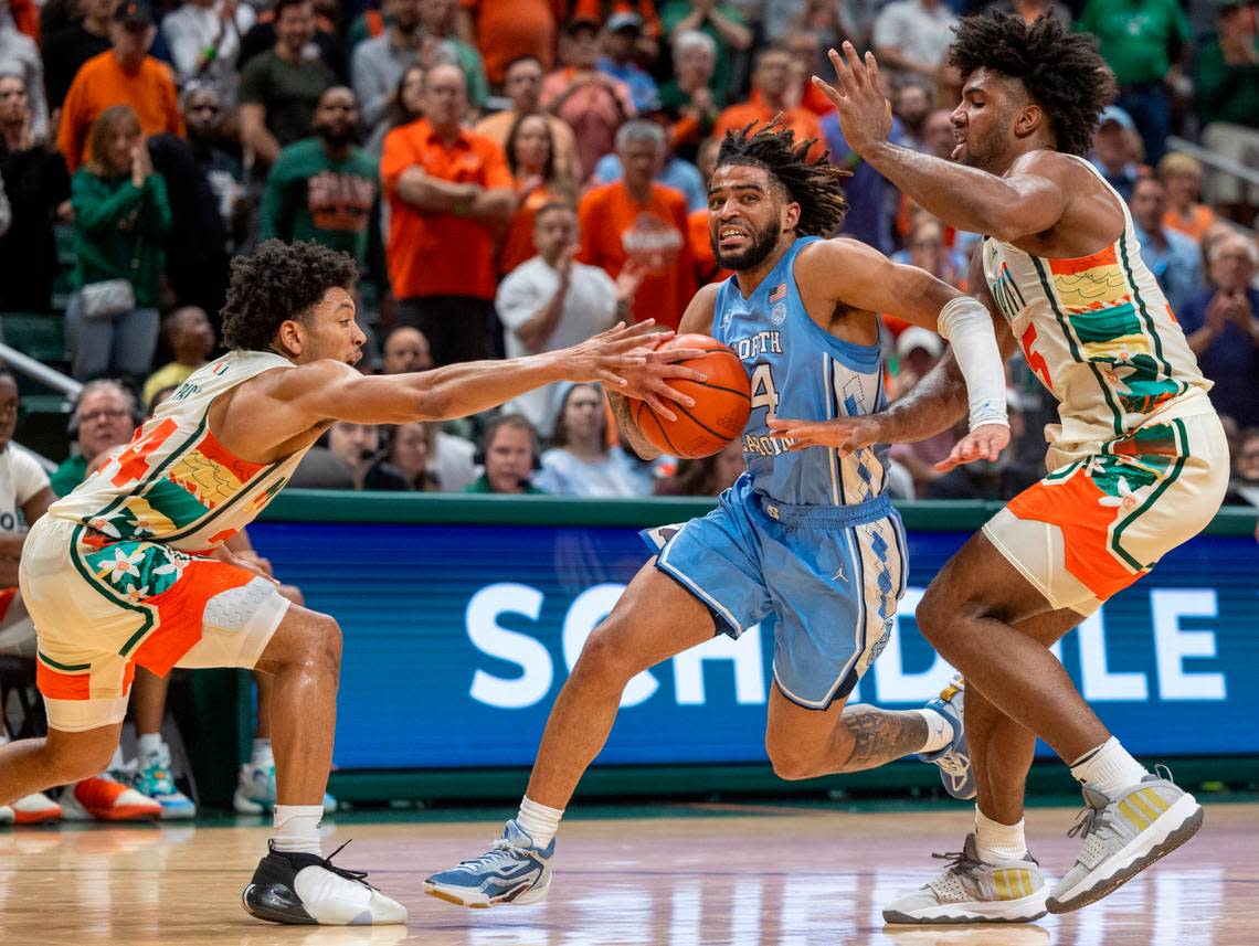 North Carolina’s R.J. Davis (4) drives to the basket between Miami’s Nijel Pack (24) and Norchad Omier (15) in the second half on Saturday, February 10, 2024 at the Watsco Center in Coral Gables, Florid