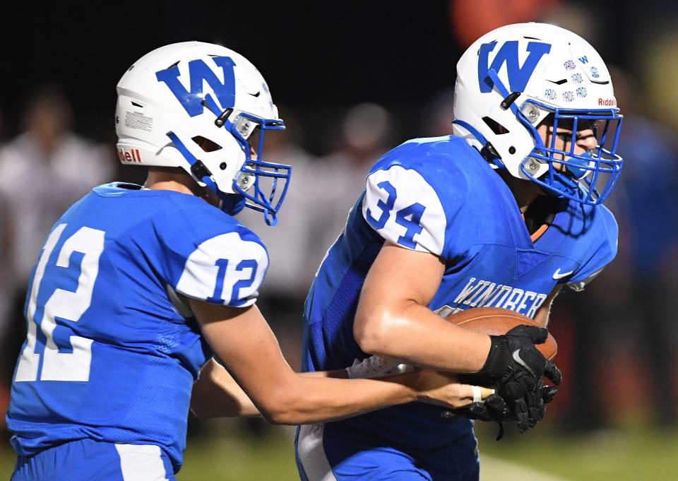 Windber quarterback Tanner Barkley (12) hands off to R.J. Tallion during an Inter-County football contest against Meyersdale, Sept. 15, in Windber.
