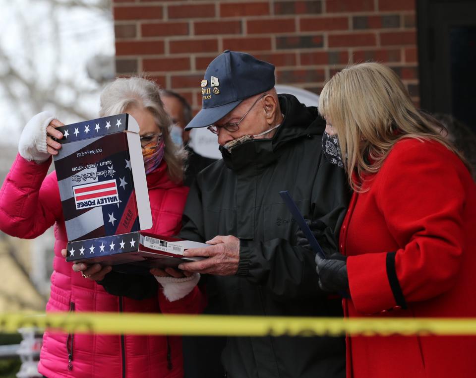 People gather outside Margeson Apartments in Portsmouth Thursday, Jan. 14, 2021 to celebrate WWII veteran Ray Goulet's 98th birthday. Goulet was on the first wave of soldiers to storm the beaches at Normandy. Due to COVID he was going to celebrate alone in his apartment.