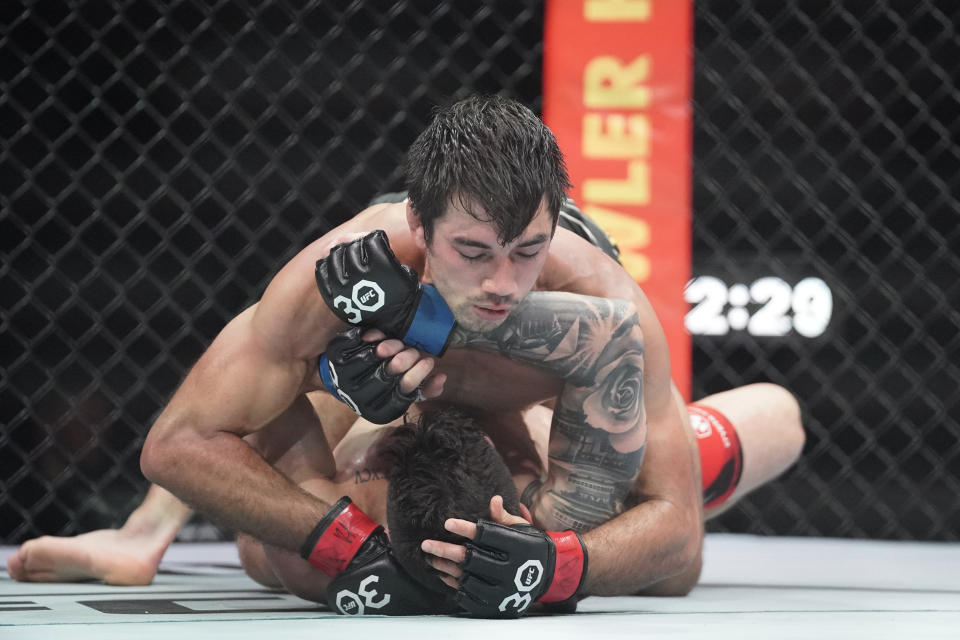 April 15, 2023;  Kansas City, Missouri, USA;  Aaron Phillips (red gloves) fights Gaston Bolanos (blue gloves) during UFC Fight Night at T-Mobile Center.  Mandatory Credit: Denny Medley - USA TODAY Sports