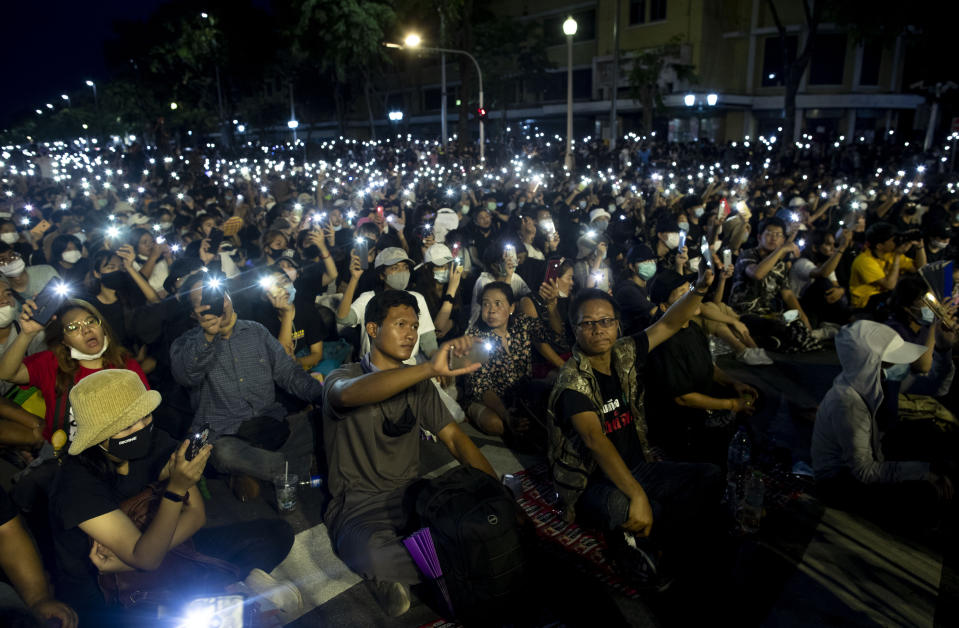 Pro-democracy activities display mobile phones with flash lights on during a protest at Democracy Monument in Bangkok, Thailand, Sunday, Aug, 16, 2020. Protesters have stepped up pressure on the government demanding to dissolve the parliament, hold new elections, amend the constitution and end intimidation of the government's opponents. (AP Photo/Gemunu Amarasinghe)