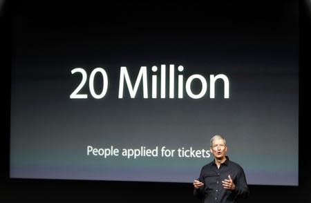 Apple Inc CEO Tim Cook talks about the iTunes Festival with the number of people applying for tickets on the screen during Apple Inc's media event in Cupertino