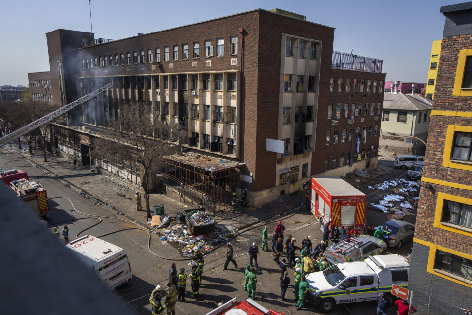 FILE - Medics and emergency works at the scene of a deadly blaze in Johannesburg Thursday, Aug. 31, 2023. A report into a building fire that killed 76 people in South Africa last year has concluded that city authorities should be held responsible because they were aware of serious safety issues at the rundown apartment block at least four years before the blaze. The nighttime fire at the five-story building in downtown Johannesburg on Aug. 31 was one of South Africa's worst disasters. At least 12 children were among the dead and another 86 people were injured. (AP Photo/Jerome Delay, File)