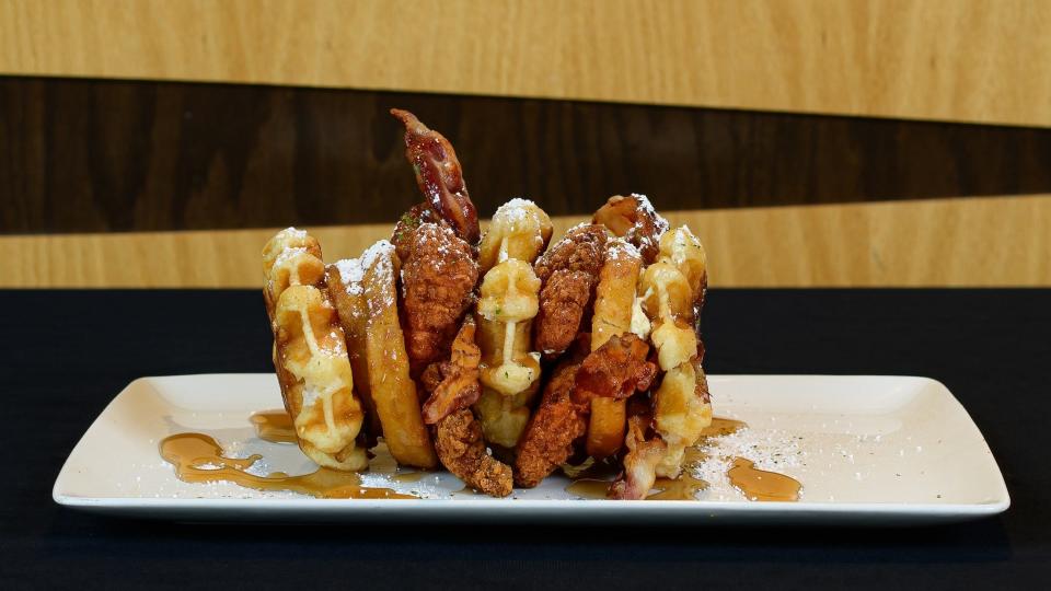 The Chicken and Waffle Sandwich on the RubberDucks extreme food menu is a double decker chicken and waffle sandwich with chicken tenders, bacon, onion rings, pimento cheese spread and a bacon habanero jam served on freshly toasted waffles with powdered sugar and maple syrup.