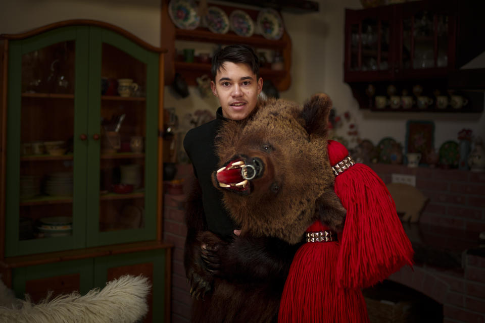 Eduard, 15 years-old, a member of the Sipoteni bear pack, poses for a portrait in Comanesti, northern Romania, Wednesday, Dec. 27, 2023. Eduard first wore the bear fur costume when he was 6 years-old, loves the outfit and making his grandparents and father proud that he continues in their footsteps by being a member of a bear pack. (AP Photo/Andreea Alexandru)