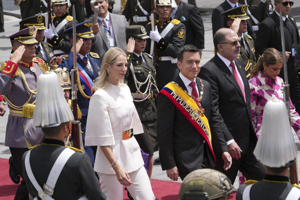 El presidente ecuatoriano Daniel Noboa y su esposa, la primera dama Lavinia Valbonesi, caminan con el presidente de la Asamblea Nacional, Henry Kronfle, al salir de la Asamblea Nacional después de que Noboa presentara su primer informe a la nación después de seis meses en el cargo en Quito, Ecuador, el viernes 24 de mayo de 2024. (AP Foto/Dolores Ochoa)