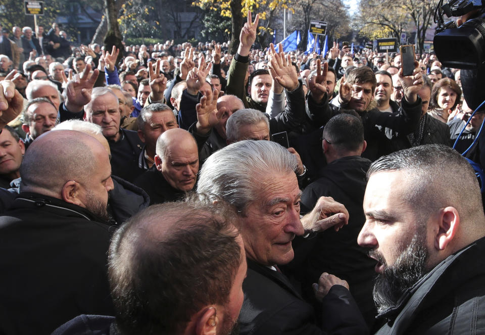 Sali Berisha, 79, the main leader of the center-right Democratic Party, center, joins hundreds of protesters as they gather outside the Parliament building in Tirana, Albania, Monday, Dec. 18, 2023. Albanian opposition have protested against the government's it accuses of corruption while a parliamentary commission discusses on immunity for its leader Sali Berisha. (AP Photo/Armando Babani)