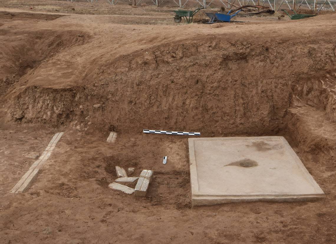 The large slab with a bowl-like indentation next to tram-like rail.