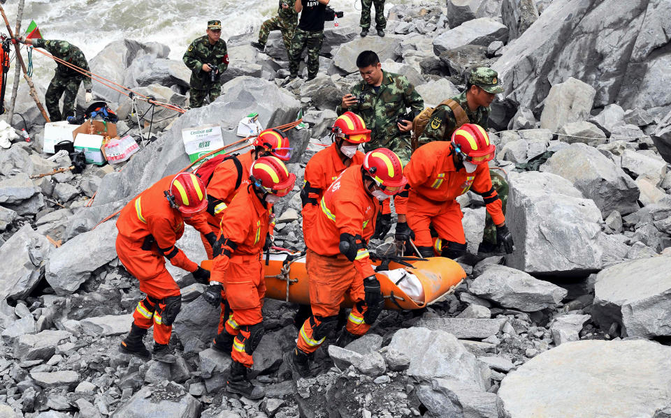 <p>Rescue workers evacuate a body from the site of a landslide in the village of Xinmo, Mao County, Sichuan Province, China, June 25, 2017. (Photo: CNS/An Yuan via Reuters) </p>