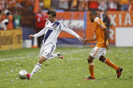 Los Angeles Galaxy's David Beckham passes the ball as Houston Dynamo's Ricardo Clark (R) defends during the second half of the MLS Cup championship soccer game in Carson, California, December 1, 2012. REUTERS/Danny Moloshok