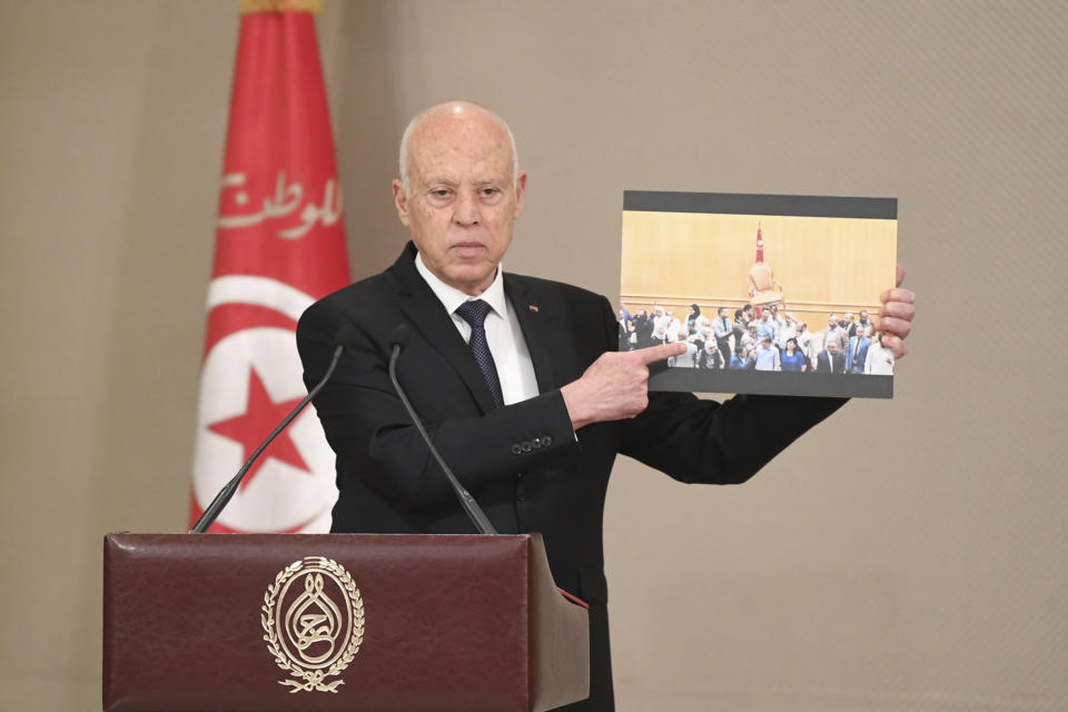 In this photo distributed by the Tunisian Presidency, Tunisian President Kais Saied shows a scene of he what he says are scuffles among lawmakers in the previous parliament, during the the swearing-in ceremony of the new government, Monday, Oct.11, 2021 in Tunis. Tunisia got a new government Monday after more than two months without one, with the prime minister naming her Cabinet, including a record number of women. (Slim Abid, Tunisian Presidency via AP)