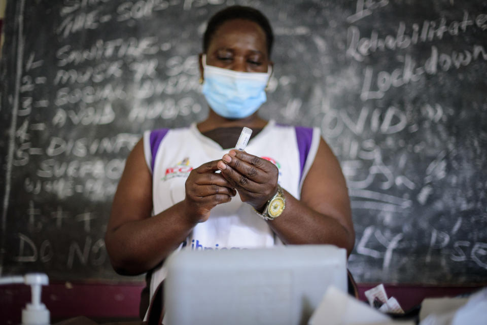 A nurse prepares to administer a coronavirus vaccination at Kisenyi Health Center in downtown Kampala, Uganda Wednesday, Sept. 8, 2021. Uganda is accelerating its vaccination drive in order to administer 128,000 doses that recently arrived and expire at the end of September. (AP Photo/Nicholas Bamulanzeki)