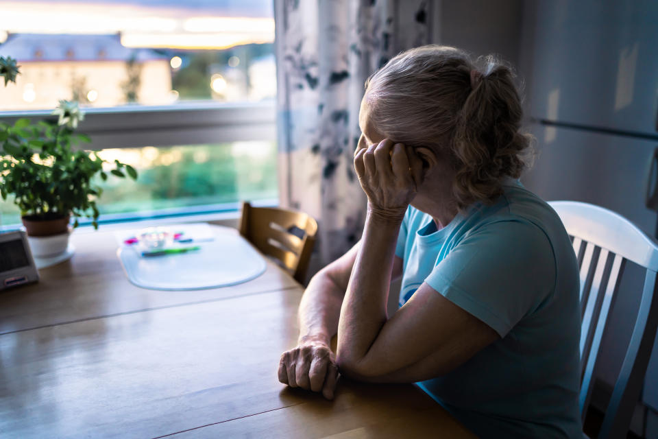 Sad old woman. Depressed lonely senior lady with alzheimer, dementia, memory loss or loneliness. Elder person looking out the home window. Sick patient with disorder. Pensive grandma. Widow with grief