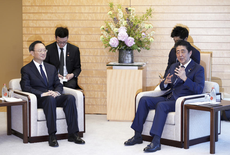 Chinese State Councilor Yang Jiechi, left, and Japanese Prime Minister Shinzo Abe, right, speak at Abe's official residence in Tokyo Friday, May 17, 2019. (AP Photo/Eugene Hoshiko, Pool)