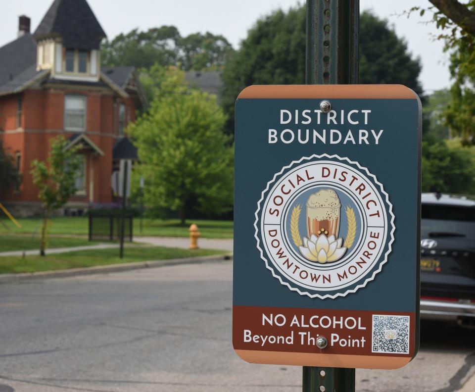 A sign posted for the social district boundary in downtown Monroe on Harrison Street looking south before Second Street.
