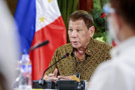 In this photo provided by the Malacanang Presidential Photographers Division, Philippine President Rodrigo Duterte talks with members of the Inter-Agency Task Force on the Emerging Infectious Diseases at the Malacanang presidential palace in Manila, Philippines late Monday Sept. 28, 2020. Only one southern Philippine province and its war-battered capital will be placed under a mild lockdown and the rest of the country will be put under more relaxed quarantine restrictions next month to boost the battered economy despite the country having the most number of coronavirus infections in Southeast Asia. (Richard Madelo/Malacanang Presidential Photographers Division via AP)