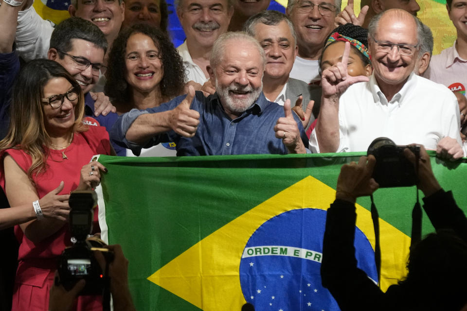 El expresidente brasileño Luiz Inácio Lula da Silva festeja con su esposa Rosangela Silva, izquierda, y su compañero de fórmula Geraldo Alckmin, derecha, luego de que la autoridad electoral dijo que venció al presidente Jair Bolsonaro para convertirse en el próximo mandatario del país, el domingo 30 de octubre de 2022, en Sao Paulo, Brasil. (AP Foto/André Penner)