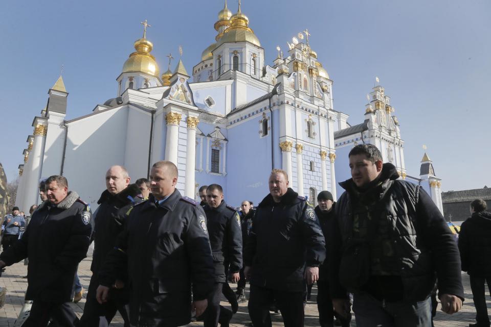 A group of police officers from western Ukraine arrive on St. Michael's Cathedral to show their support for the opposition in Kiev, Ukraine, Friday, Feb. 21, 2014. Ukraine's president gave in to pressure from European diplomats and offered concessions Friday to defuse a crisis that has divided his country and left scores dead. Shots rang out near Kiev's protest camp and protesters fought among themselves about what to do next.(AP Photo/Efrem Lukatsky)