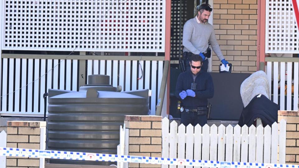 Police in front of the house where the bodies were found.