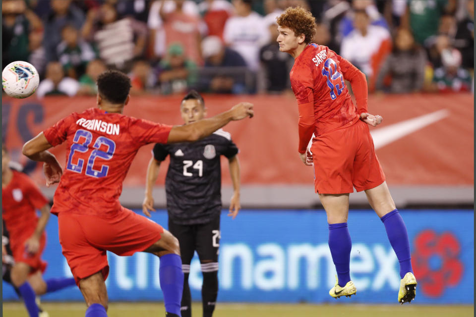 In this photo taken Sept. 6, 2019, United States forward Josh Sargent, right, goes airborne while passing the ball to a teammate in the second half of an international friendly soccer match against Mexico in East Rutherford, N.J. After scoring his first goal of the season for Werder Bermen with a spectacular shot, 19-year-old Sargent hopes to play for the United States in his hometown during Tuesday's exhibition against Uruguay at Busch Stadium. (AP Photo/Kathy Willens)