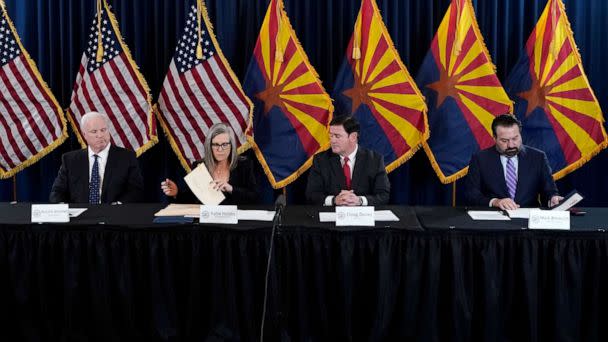 PHOTO: Arizona Democrat governor-elect and current Arizona Secretary of State Katie Hobbs, second from left, signs the official certification for the Arizona general election canvass in a ceremony at the Arizona Capitol in Phoenix, Dec. 5, 2022. (Ross D. Franklin/AP)