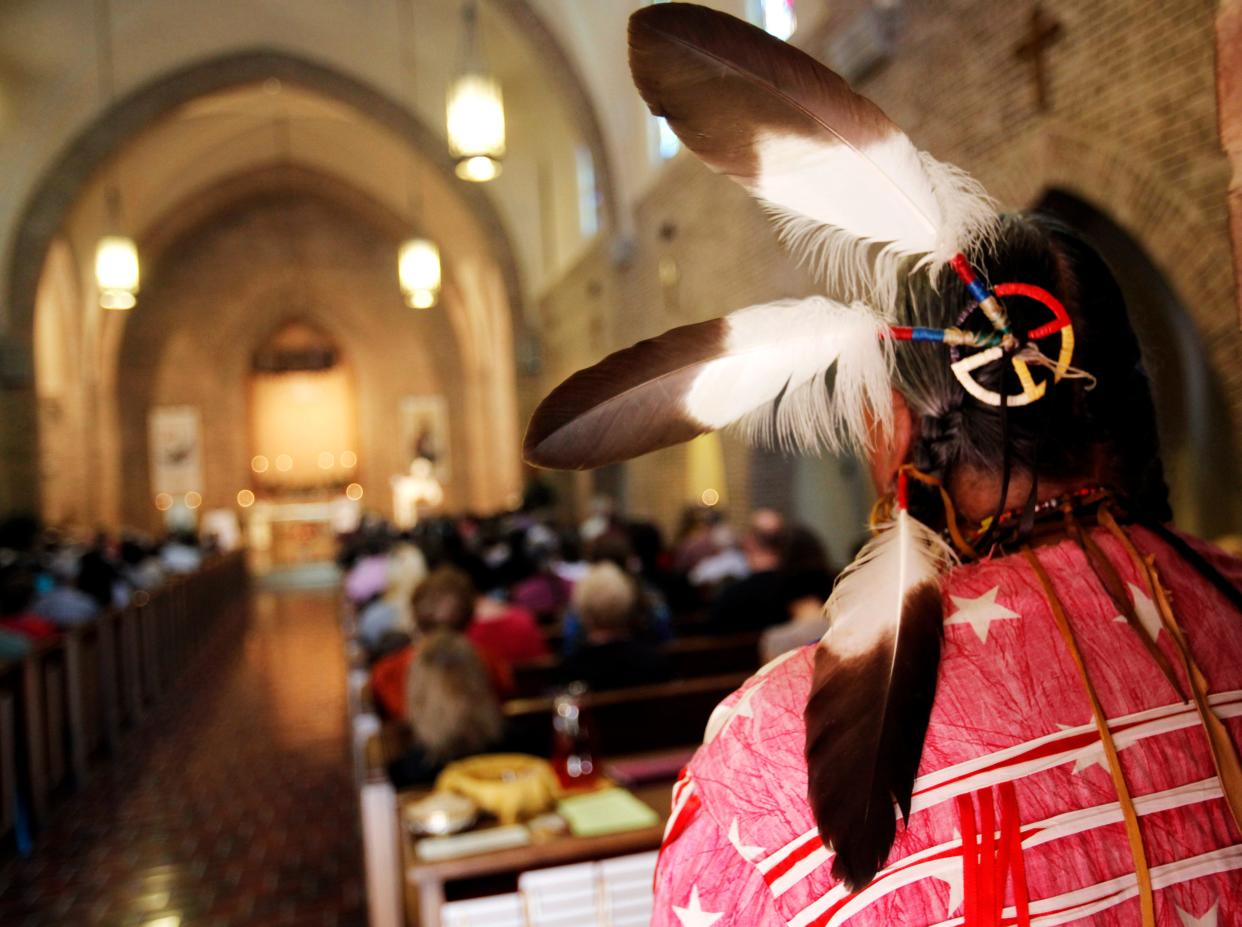 A man stands at the back of the Abbey Church at St. Gregory's Abbey during Mass in 2013 for the celebration of a feast day for Saint Kateri Tekakwitha in Shawnee. Tekakwitha is the first Native American canonized by the Roman Catholic Church in October 2012.