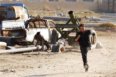 A Free Syrian Army fighter runs to safety just before a mortar is fired toward forces loyal to President Bashar al-Assad in Raqqa, eastern Syria November 14, 2013. REUTERS/Nour Fourat