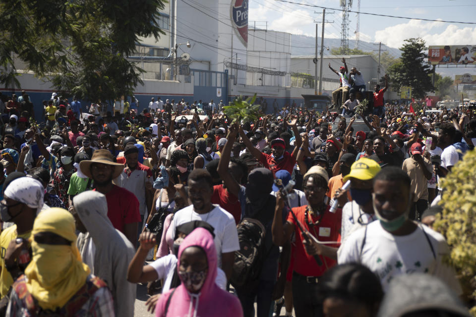 Factory workers march to demand a salary increase in Port-au-Prince, Haiti, Wednesday, Feb. 23, 2022. It is the first day of a three-day strike organized by factory workers who also shut down an industrial park earlier this month to protest pay. (AP Photo/Odelyn Joseph)