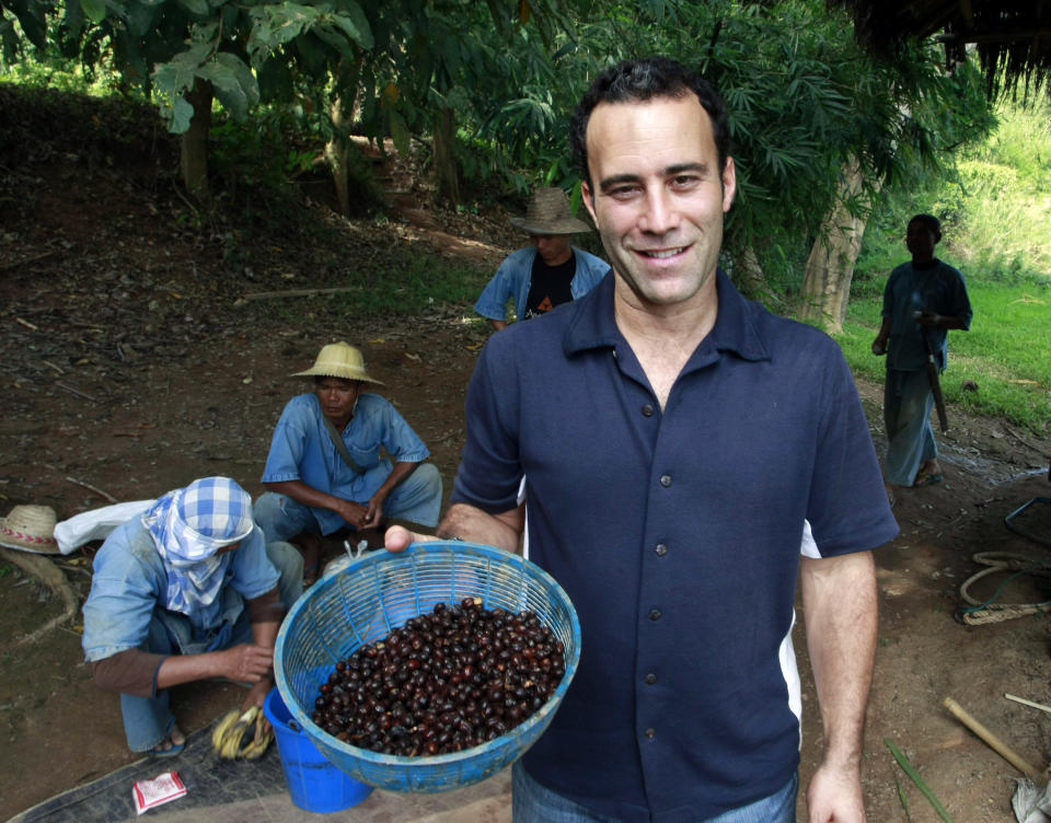 HOLD FOR THAILAND ELEPHANT COFFEE BY JOCELYN GECKE- In this photo taken Dec. 3, 2012, Blake Dinkin, founder of Black Ivory Coffee, holds a basket of coffee beans to mix with other fruits before feeding to elephants at an elephant camp in Chiang Rai province, northern Thailand. Dinkin, 37, a Canadian entrepreneur with a background in civet coffee, has teamed up with a herd of 20 elephants, gourmet roasters and one of the country's top hotels to produce the Black Ivory, a new blend from the hills of northern Thailand and the excrement of elephants which ranks among the world's most expensive cups of coffee. (AP Photo/Apichart Weerawong)