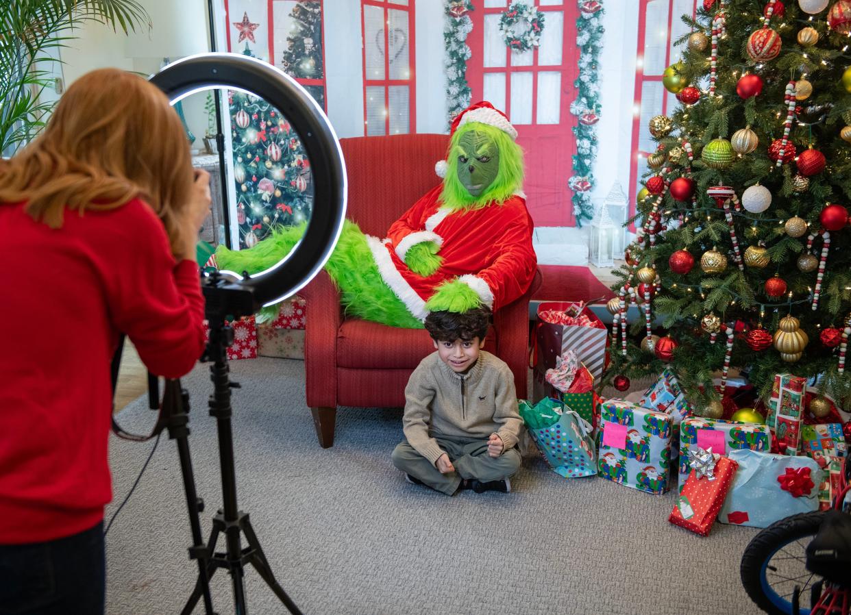 A child gets his photo taken with the Grinch during a charity brunch for the Ronald McDonald House. Photographers are warning other professionals online about doing Grinch-themed photo shoots for profit, which might get them in trouble with Seuss Enterprises.