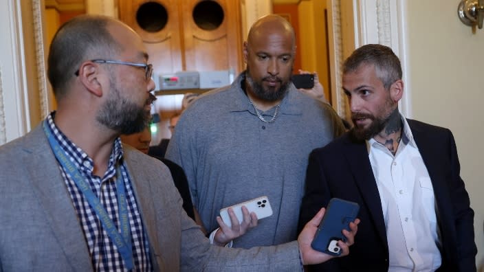 U.S. Capitol Police Officer Harry Dunn (center) and Metropolitan Police Officer Michael Fanone (right) answer questions while leaving the office of House Minority Leader Kevin McCarthy late last month in Washington, D.C. (Photo by Win McNamee/Getty Images)