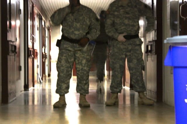 Guards at Camp Five stand watch during morning prayers.