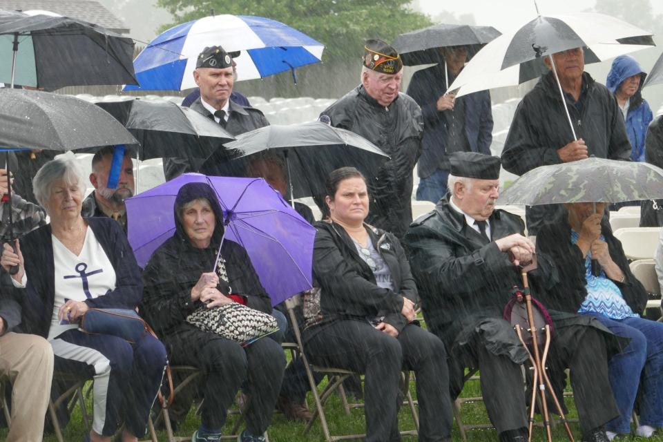Members of the public and military veterans watch the ceremonies for the unveiling of the statue of George Washington at Washington Crossing National Cemetery in Upper Makefield during a rainstorm Saturday.