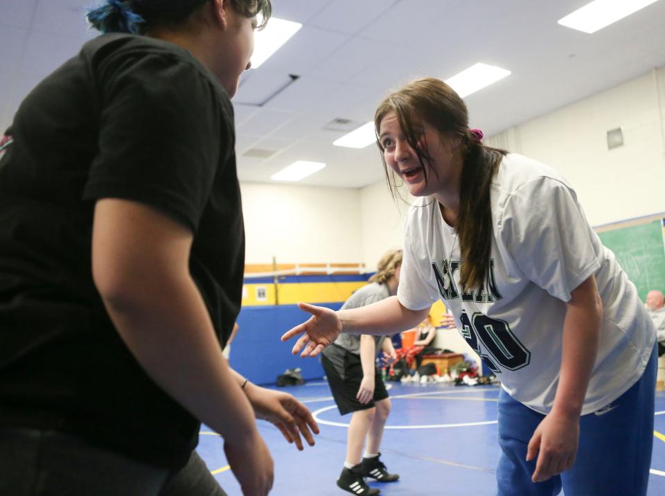 McKean's Paris Hartnett, right, is paired with Denise Sanroman as Hartnett helps out with workouts at a girls wrestling clinic at A.I. du Pont High School, Tuesday, March 21, 2023.