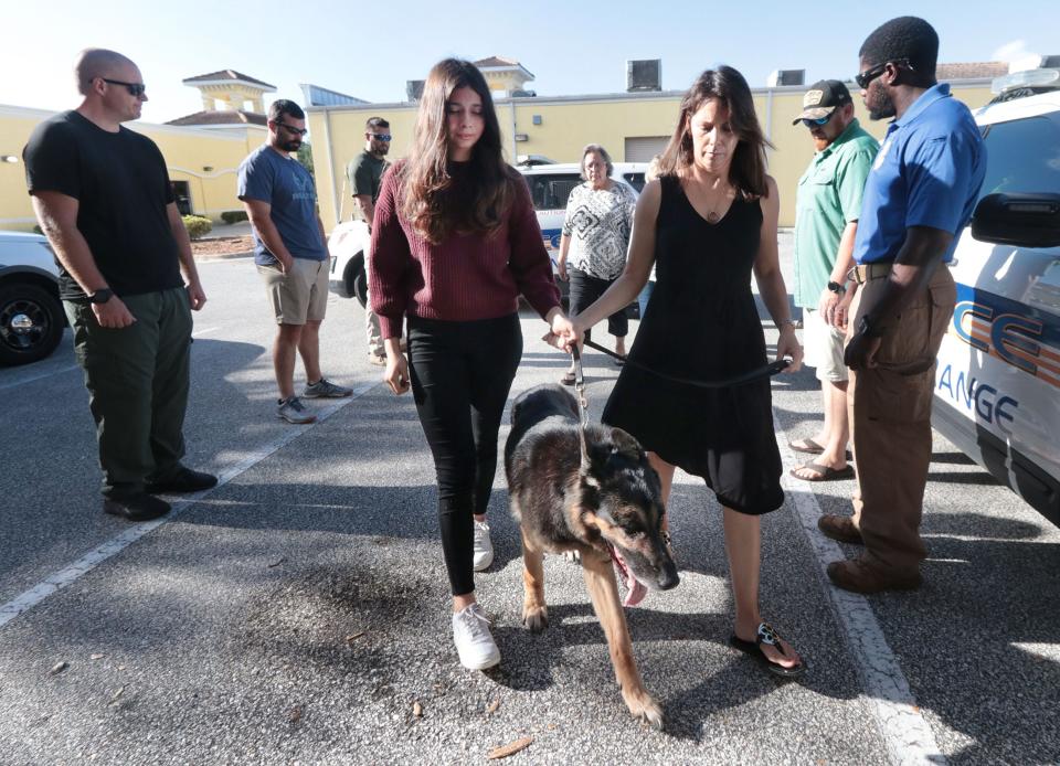 Carlyn White, widow of Port Orange Police Sgt. Justin White, is joined by her daughter Savannah on Friday to walk her husband's K9 partner Rex past a line of Port Orange police officers at Freiberg's Healing Paws Veterinary clinic in Ormond Beach. The 14-year-old K9 had to be put down due to serious health issues. Officer White died of complications from COVID-19 on Aug. 5, 2021.