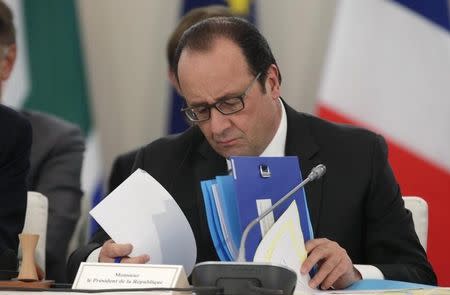 French President Francois Hollande reads his notes as he attends "The Climate Challenge and African solutions" event during the World Climate Change Conference 2015 (COP21) at Le Bourget, near Paris, France, December 1, 2015. REUTERS/Philippe Wojazer