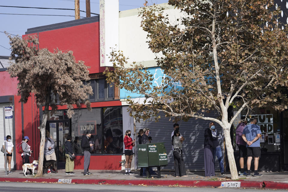 Patrons keep their social distance while waiting for donuts outside Donut Friend bakery in the Highland Park neighborhood of Los Angeles, Saturday, Nov. 6, 2021. A vaccine mandate that is among the strictest in the country takes effect Monday, Nov. 8, in Los Angeles, requiring proof of shots for everyone entering a wide variety of businesses from restaurants to shopping malls and theaters to nail and hair salons. (AP Photo/Damian Dovarganes)