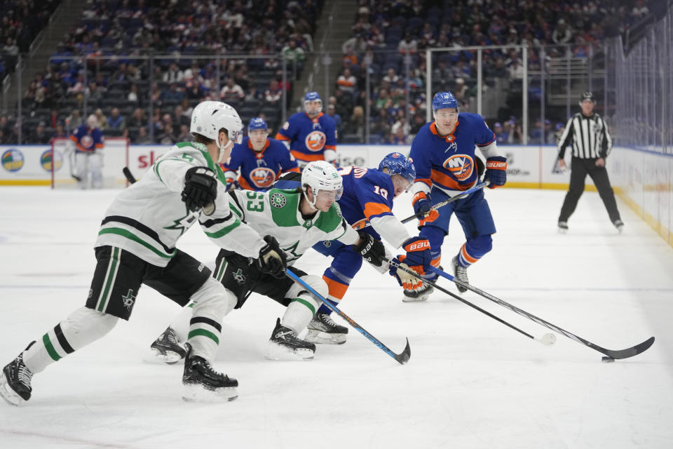New York Islanders right wing Simon Holmstrom fights for the puck against Dallas Stars center Wyatt Johnston and defenseman Nils Lundkvist during the second period of an NHL hockey game, Sunday, Jan. 21, 2024, in Elmont, N.Y. (AP Photo/Mary Altaffer)