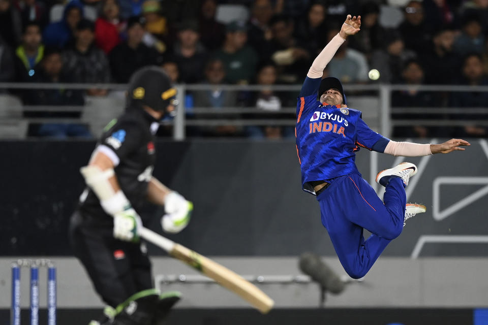 India's Shubman Gill, right, leaps as he attempts to take a catch out New Zealand's Tom Latham, left, during their one day international cricket match in Auckland, New Zealand, Friday, Nov. 25, 2022. (Andrew Cornaga/Photosport via AP)