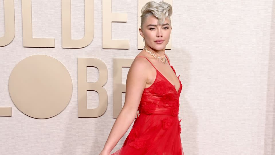 Florence Pugh sported a platinum faux-hawk and a sheer red Valentino gown embellished with flower detailing. - Jon Kopaloff/WireImage/Getty Images