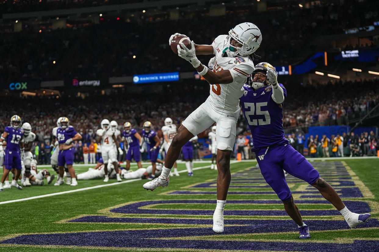 Texas Longhorns wide receiver Adonai Mitchell (5) makes a touchdown catch over Washington cornerback Elijah Jackson during the Sugar Bowl College Football Playoff semifinals game at the Caesars Superdome on Monday, Jan. 1, 2024 in New Orleans, Louisiana. The catch would be the last touchdown for the Longhorns in the 31-37 loss to Washington.