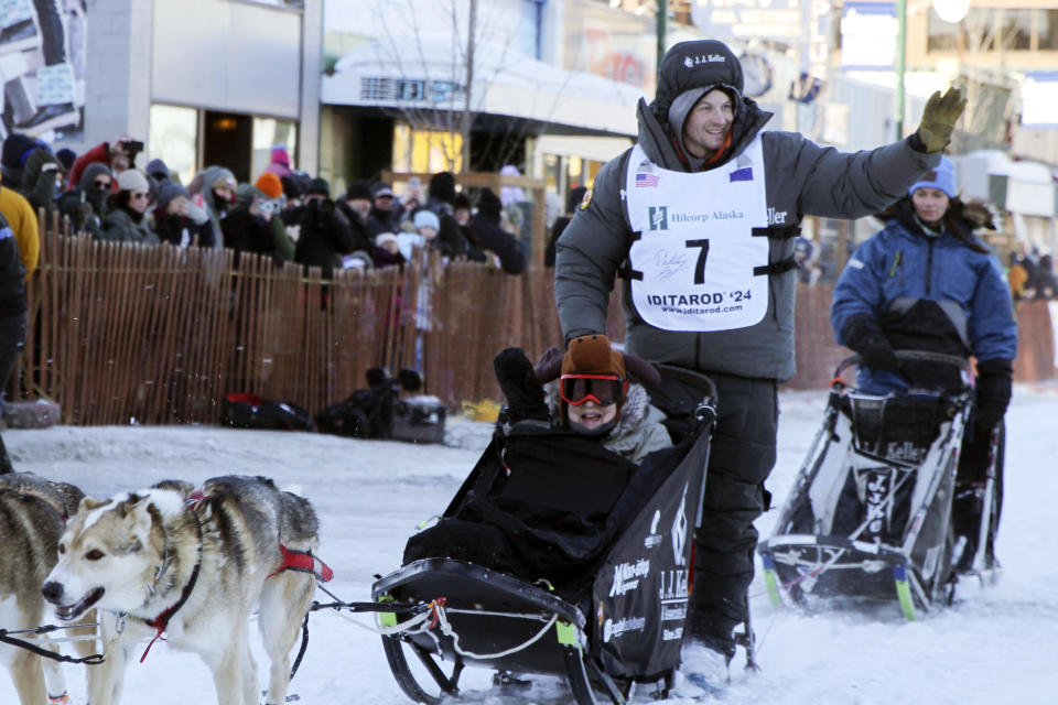 FILE - Dallas Seavey (7), of Talkeetna, Alaska, takes an auction winner in his sled 11 miles over the streets of Anchorage, Alaska, during the March 2, 2024, ceremonial start of the Iditarod Trail Sled Dog Race. Seavey overcame killing a moose and receiving a time penalty to win the Iditarod on Tuesday, March 12, 2024, a record-breaking sixth championship in the world’s most famous sled dog race. (AP Photo/Mark Thiessen, File)