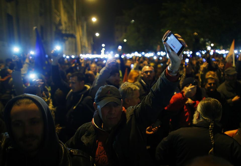 People hold up their mobile phones as they protest against a new tax on Internet data transfers in the centre of Budapest, October 28, 2014. REUTERS/Laszlo Balogh (HUNGARY - Tags: BUSINESS TELECOMS CIVIL UNREST)