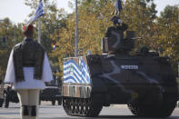 A tank with a Greek Flag painted on the side parades through the streets of the northern port city of Thessaloniki, Greece, during a military parade, on Thursday, Oct. 28, 2021 .The parade is held to celebrate Greece's refusal to align itself with a belligerent fascist Italy in 1940 and instead fight a much stronger opponent, a decision which dragged it into World War II and eventually led to a brutal occupation by Nazi Germany. (AP Photo/Giannis Papanikos)