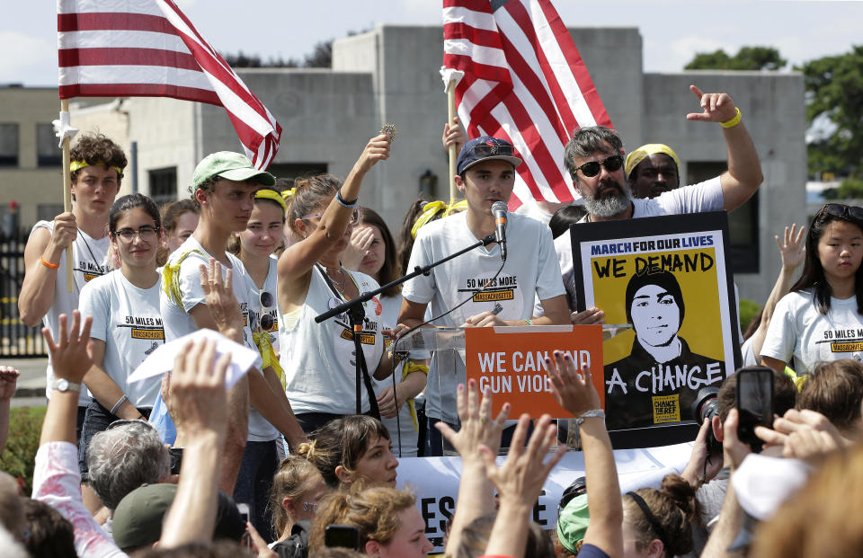 David Hogg, center, a survivor of the school shooting at Marjory Stoneman Douglas High School, in Parkland, Florida, addresses a rally in front of the headquarters of gun manufacturer Smith & Wesson, Sunday, Aug. 26, 2018, in Springfield, Mass. The rally was held at the conclusion of a 50-mile march meant to call for gun law reforms that began Thursday, Aug. 23, 2018, in Worcester, Mass., and ended Sunday, in Springfield, near the gun manufacturer. (AP Photo/Steven Senne)