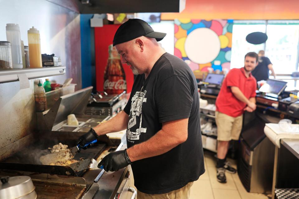 Andy Clarke. founder and owner, grills up a "Duuuval Cheesesteak" and a chicken cheesesteak as his son and co-worker Aedan Clarke looks on at their newly opened restaurant, Clarke Bros Subs in Jacksonville's Riverside neighborhood.