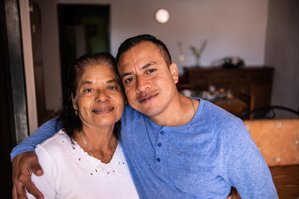 Woman and man smiling and embracing in a home kitchen