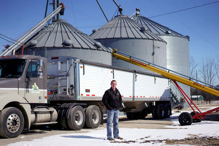Soybean farmer Austin Rincker poses for a photograph near a grain truck and storage bins at his farm in Moweaqua, Illinois, U.S., March 6, 2019. REUTERS/Daniel Acker/Files