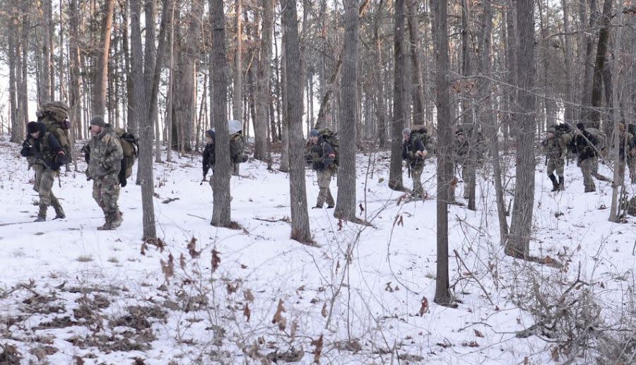 Special Forces candidates assigned to the U.S. Army John F. Kennedy Special Warfare Center and School hike through woods near Raeford, North Carolina during the final phase of field training known as Robin Sage in central North Carolina, January 23, 2022.(U.S. Army photo by K. Kassens)