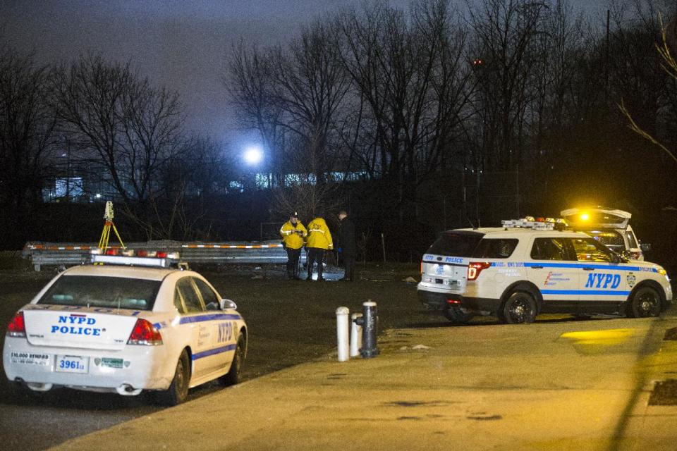 Police investigate the scene of an accident on a dead-end street where a car containing five passengers plunged into Steinway Creek in the Astoria neighborhood of Queens, Saturday, April 5, 2014, in New York. The New York Police Department says four of five people pulled from a vehicle submerged in a New York City creek have died. The fifth apparently escaped serious injury and is in stable condition. (AP Photo/John Minchillo)